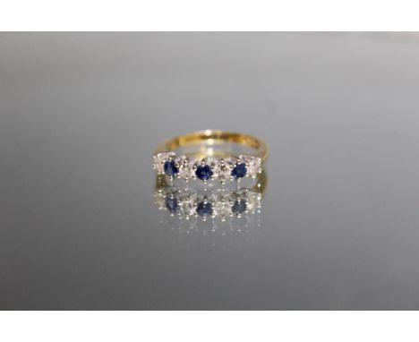 AN 18 CARAT YELLOW GOLD SAPPHIRE AND DIAMOND RING, set with three sapphires totalling an estimated 0.30 carat and four diamon