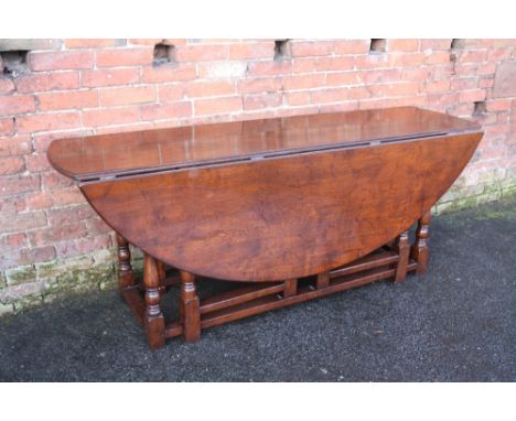 A QUALITY OAK TWO FLAP HUNT TABLE, the oval top supported by a twin gate leg mechanism to each side, H 76 cm, W 158 cm, L 198