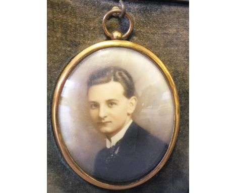 AN EARLY 20TH CENTURY OVAL PORTRAIT MINIATURE ON IVORINE, young gentleman in black jacket and cravat, unsigned, in a gold met