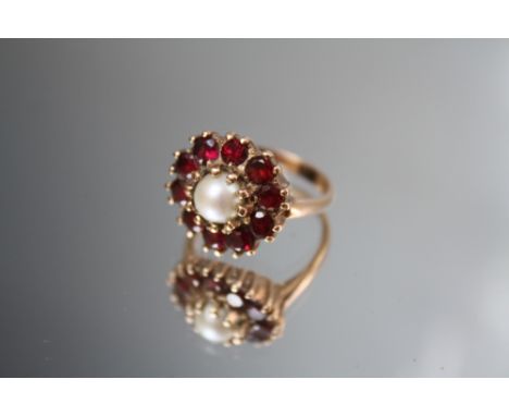 A HALLMARKED 9CT GOLD PEARL AND GEMSET DRESS RING, the single pearl surrounded by ten garnet type gemstones. approx. W 5.3 g