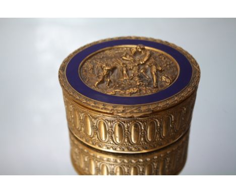 A 20TH CENTURY OVAL GILT METAL LIDDED TRINKET, with Regency style relief figural decoration with inset blue ceramic panel to 