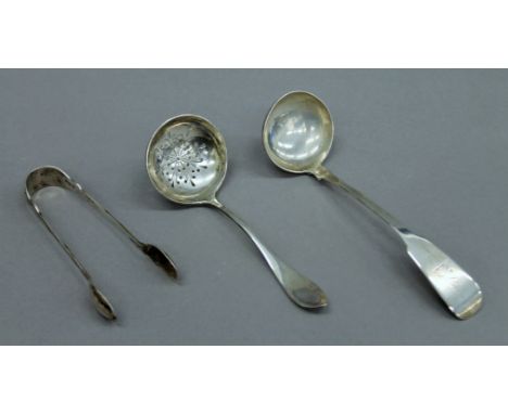 A silver sifter spoon, a pair of silver tongs and a silver sauce ladle. 87.1 grammes.