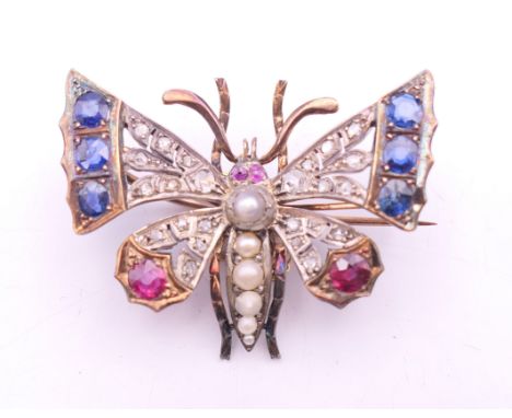 An unmarked gold and silver diamond, sapphire, ruby and pearl set brooch formed as a butterfly.  4 x 3 cm. 12.6 grammes total