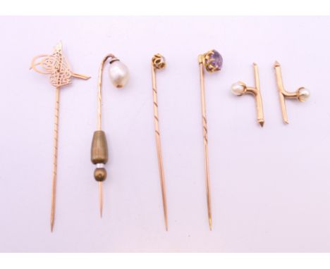 A quantity of unmarked gold tie pins including a natural pearl example. 8 grammes total weight.