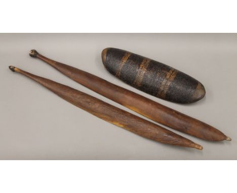 Two Aboriginal spear throwers of typical form, with gum ends (the largest 87 cm long) and a shield shaped wood implement with