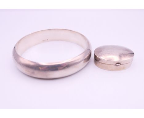 A silver pill box and a silver bangle. Bangle 6.5 cm internal diameter.