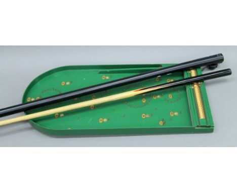 A snooker que and a bagatelle board.