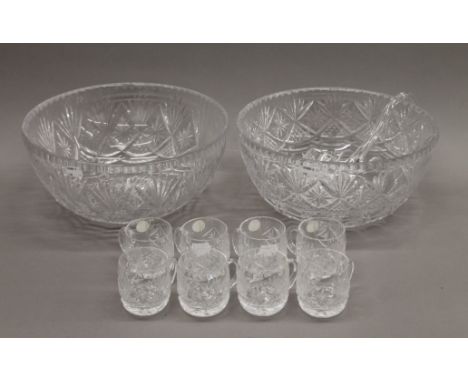 Two cut glass punch bowls, cups and a ladle. The largest 31 cm diameter.