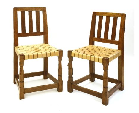 Two Robert 'Mouseman' Thompson oak chairs, with vertical splats and latticed leather slats, united with plain stretchers, wit