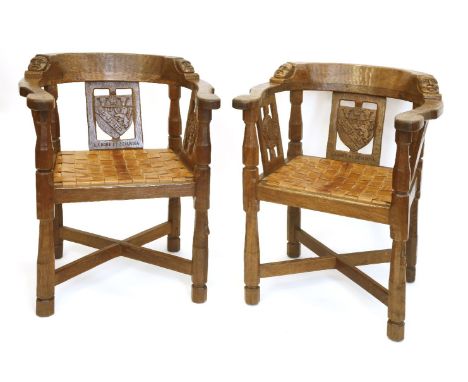 A pair of Robert ‘Mouseman’ Thompson monk’s armchairs, each back rail with a carved boss and a mask, the central splat with a