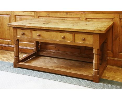 A Robert 'Mouseman' Thompson oak side table, the adzed top over three drawers raised on octagonal supports, united with a pla