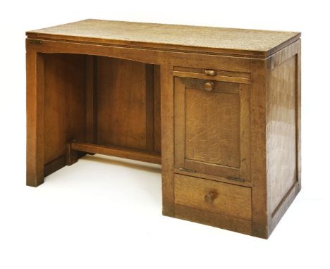 A Robert ‘Mouseman’ Thompson oak desk, the adzed top over a kneehole with a slide, the handle with mouse signature, over a ba