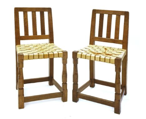 Two Robert ‘Mouseman’ Thompson oak typist’s chairs, with plain vertical splats, and latticed leather seats, mouse signature t