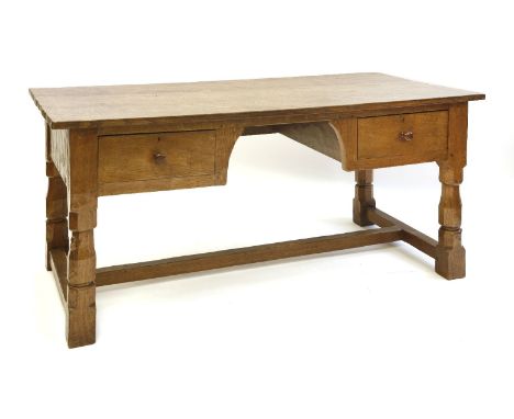 A Robert 'Mouseman' Thompson oak library table, with an adzed top over two drawers either side of a kneehole, raised on octag