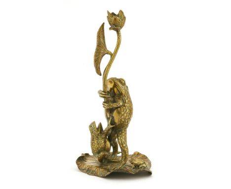 A brass candlestick,modelled as frogs standing on a lily pad, holding a flower that forms the candle sconce,32cm high