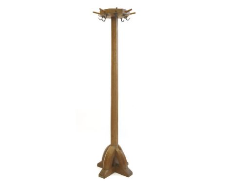 A Robert 'Mouseman' Thompson oak coat stand, the octagonal top with eight pegs and eight hooks, on a raised arch cross stand,