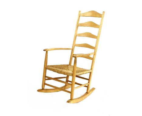 An ash ladder back rocking chair,by Neville Neal, after a design by Ernest Gimson, with a rush seat, stamped to upright