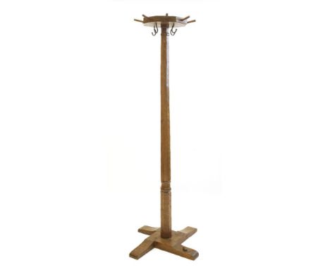 A Robert ‘Mouseman’ Thompson oak coat stand, the octagonal top with eight pegs and four iron hooks, on a flat four-platform b