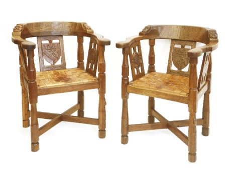 A pair of Robert 'Mouseman' Thompson monk’s armchairs, each back rail with carved bosses, the central splat with a shield car