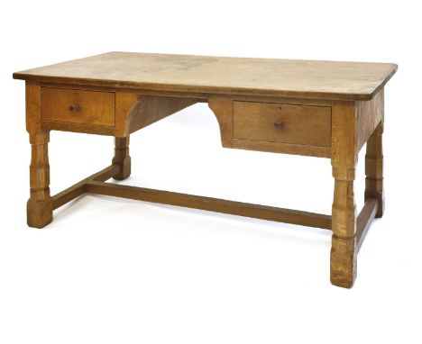 A Robert 'Mouseman' Thompson oak library table, with an adzed top over two drawers either side of a kneehole, raised on octag