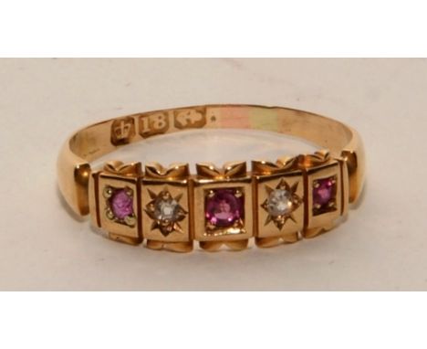 An 18ct gold ruby and diamond gypsy ring, with three graduated round cut rubies interspersed by two old cut diamonds in star 