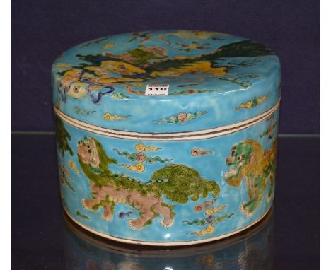 A large Chinese ceramic box with cover, decorated with green and yellow dogs on turquoise ground, with character marks to bas