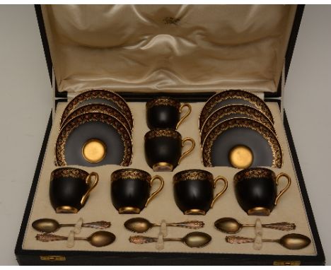 A Royal Worcester porcelain six setting coffee service, in fitted box, with gilded foliate decoration on black ground and six