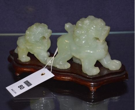 A Chinese jade coloured hardstone 'Dog of Foe' figure group, raised on wood stand, 10cm high x 18.5cm wide