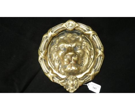 A heavy brass door knocker with lion's head back plate and ribbon-tied knocker, approx. 9'' diam.