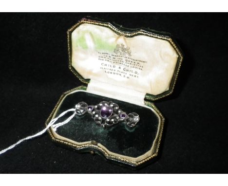 A Continental silver amethyst and white paste-set brooch in a Child & Child green leather case