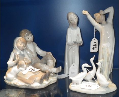 A Lladro figure of a young girl carrying a candle and others similar