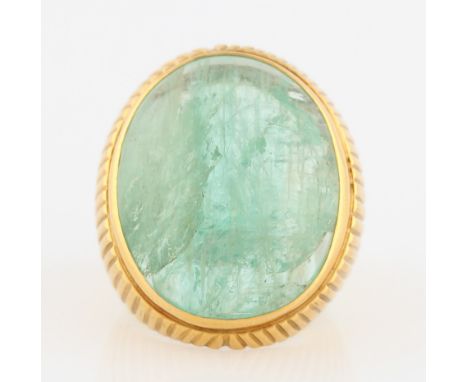 An emerald ring, set with an emerald cabochon, measuring approx. 25x20mm, metalwork featuring linear design surrounding caboc