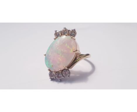 A yellow gold marked 750, opal and diamond cross over ring, with three diamonds either side, each diamond approx. 0.10cts, ri