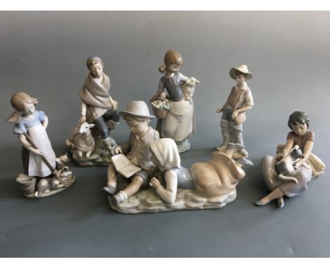 Five Lladro figurines including girl with lamb (finger chipped), girls with cats, boy and girl reading with one Nao figurine 