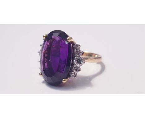 A yellow gold marked 750, amethyst and diamond cluster ring, with five small diamonds either side of amethyst, ring size H, a