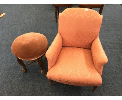 A pink upholstered chair with an oak four leg stool with claw and ball feet. IMPORTANT: Online viewing and bidding only.&nbsp