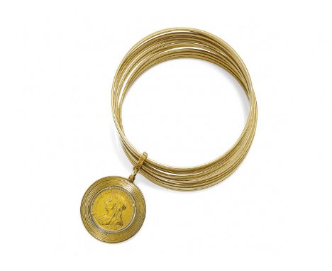 BRACCIALE CON PENDENTE composto da dodici cerchietti rigidi in oro giallo a lastra e pendente con una sterlina. Gr 95,80 -  d