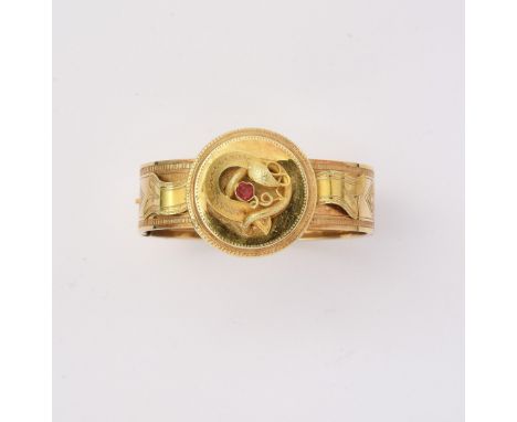 ANTICO BRACCIALE RIGIDO, CIRCA 1870 in oro rosa lavorato a lastra incisa, con motivo centrale rotondo in pasta vitrea rossa. 