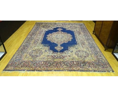 An Eastern carpet, the large multicoloured floral medallion on blue ground with intricate multicoloured floral borders, 343 x