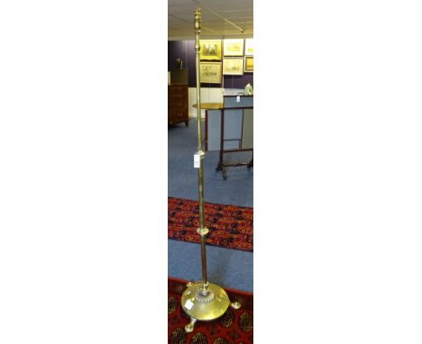 An Art Noveau brass telescopic floor lamp, raised on hammered circular base with stylised feet, converted to electricity, 50,