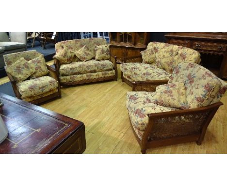 An Ercol bergere four piece suite, comprising of two two-seater settee's and two armchairs, upholstered in pale yellow floral