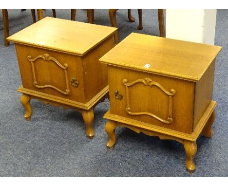 A pair of light oak bedside cupboards, raised on cabriole supports, 56cm high x 51cm wide x 37cm deep