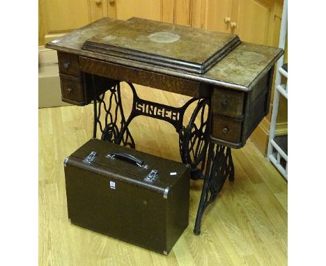 A vintage treadle oak Singer Sewing machine, circa 1921, with lever top revealing black and gilt decorated sewing machine wit
