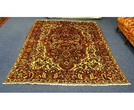 A Bakhtiari carpet, the large central multicoloured floral motif in reds, blacks and beiges surrounded by similar foliate mot