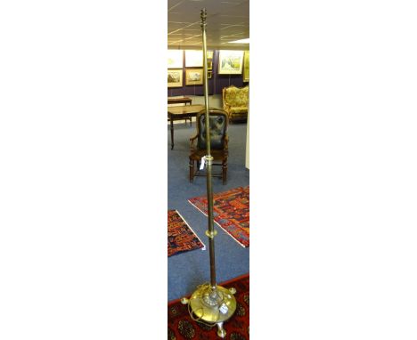 An Art Noveau brass telescopic floor lamp, raised on hammered circular base with stylised feet, converted to electricity, 178