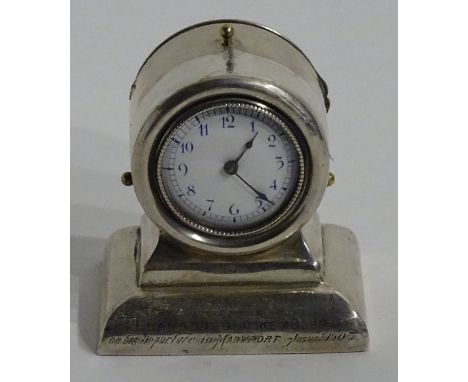 A silver clock, hallmarks for London GY & Co, date letter rubbed, the white enamel face with blue Arabic numerals, the plinth