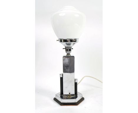 An early 20th Century Art Deco table lamp having a ribbed opaline globe glass shade raised on a black marble and chrome geome