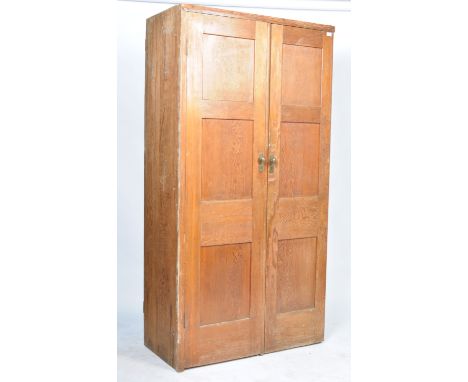 A stunning early to mid 20th Century antique vintage pitch pine wardrobe having twin triple panelled doors revealing a hangin