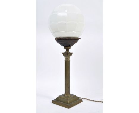 An early 20th Century Art Deco table lamp having a ribbed opaline globe glass shade raised on a silver plated Classical Compo