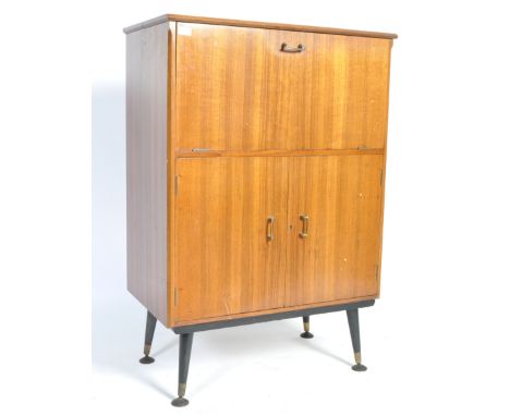 An original 1950's retro vintage teak wood cocktail cabinet having a drop front cocktail section with metamorphic action reve